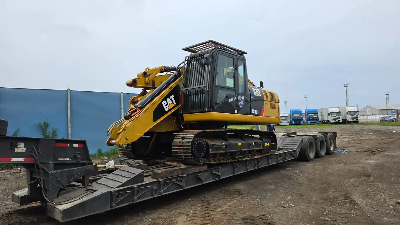 Excavadora CAT sobre una cama baja para su movilización terrestre
